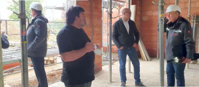In kleiner Runde wird die Richtkrone gesetzt: Den Richtspruch hält Max Schackert. Die Projektbeteiligten stoßen mit einem kleinen Schluck auf die neue Kita an der Westallee in Gronau an, die im Dezember fertiggestellt sein soll, so dass der Nachwuchs im Januar den Bewegungsraum der Kindertagesstätte (Foto unten) und alle anderen Räume beziehen kann.